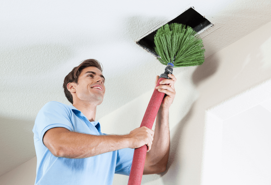 a man keeping air ducts clean of mold and bacteria with a broom